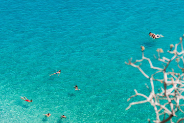 People swimming in crystal clear water