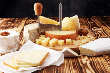 various types of cheese on rustic wooden table. cheese platter