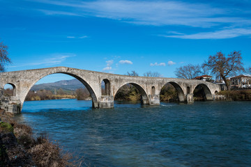 Fototapeta na wymiar Bridge of Arta in Greece. A stone bridge that crosses the Arachthos river in the west of the city of Arta. The folk ballad 