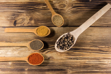 Assorted spices in wooden spoons on a table