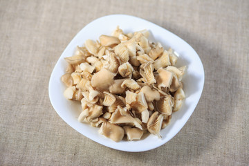 Marinated mushrooms champignons on a plate on a gray background