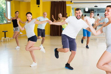 Fototapeta na wymiar Positive men and women are dancing boogie-woogie in pairs