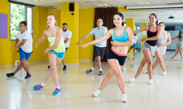 Modern active males and females dancing excited posing in studio