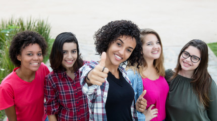 Latin american woman showing thumb with group of girlfriends