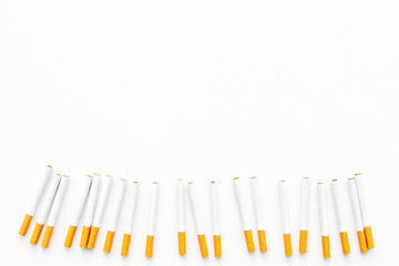 Tobacco. Row of cigarettes on white background top view copyspace