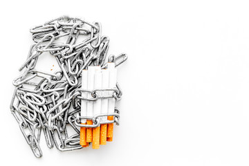 Quit smoking. Cigarettes in chains on white background top view copyspace