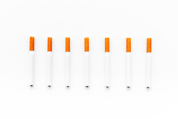 Tobacco. Row of cigarettes on white background top view