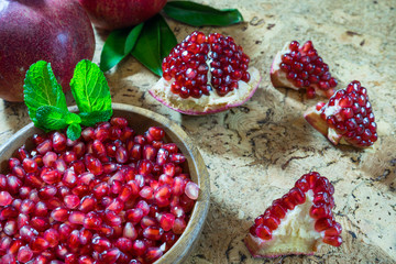 Pomegranate grains in a wooden bowl closeup
