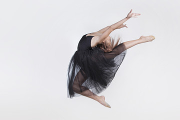 Dancer wearing black transparent dress. Performs jump up