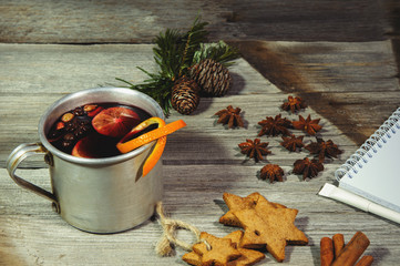 Traditional fruity mulled wine from the old mug, on an old wooden table