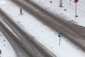 Blue sign with white arrow on road during winter