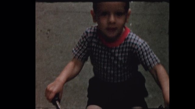 1956 Little boy rides Tricycle down NYC street