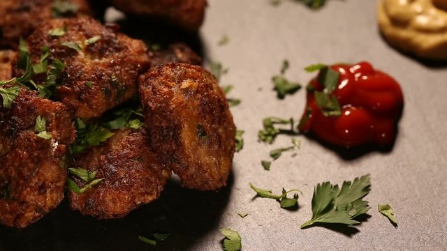 Spreading fresh parsley on meatballs on plateau