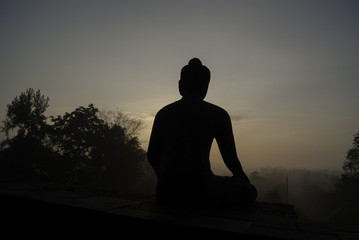 buddha statue against the misty sunrise