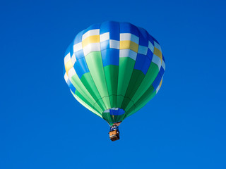 Naklejka premium Colorful hot air balloon flying in the bright blue sky during Winthrop Balloon Festival in Washington state