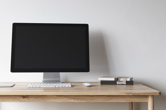 Blank computer screen on a wooden desk