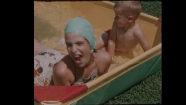 1956 Little boy and girl play in kiddie pool  Close Up 