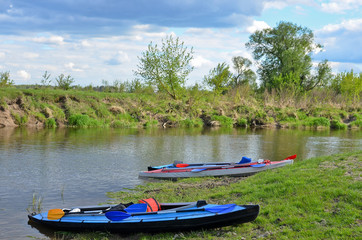 Fototapeta na wymiar Canoes on the river bank at beautiful weather in summer.