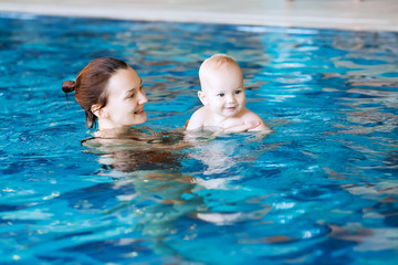 Smiling charming baby in swimming pool