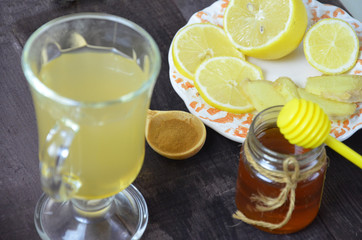 Hot drink with honey, lemon and ginger for cough remedy on wooden table