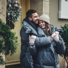 Couple has fun and laughs. kiss. Young hipster couple hugging each other in winter park. Winter love story, a beautiful stylish young couple. Winter fashion concept with boyfriend and girlfriend.