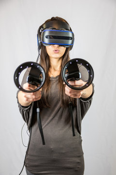 Junge Frau mit Virtual Reality Datenbrille und zwei Controllern