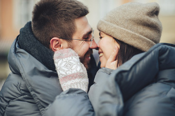 Fototapeta premium Classy groom and his gorgeous bride pose outside in winter coats