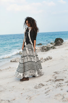 stylish young fashionable woman walking on the beach