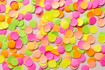 Carnaval party background concept. Space for text, copyspace. Colorful confetti spread over table. Warm colors