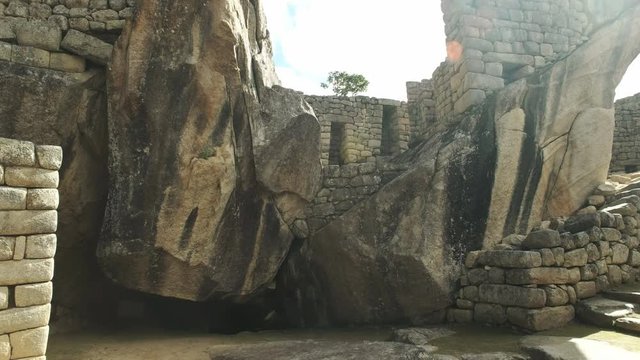 tilt up shot of the temple of the condor at peru's famous lost incan city of machu picchu