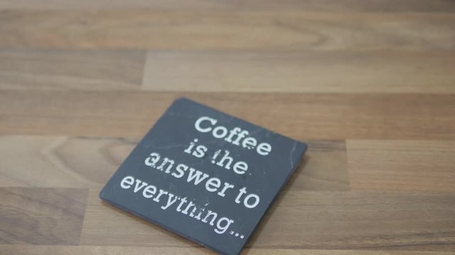 Coffee is everything. Hand taking cappuccino off coaster