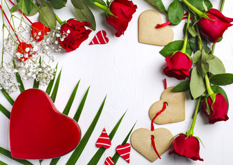 Red roses, gift box and heart shapes cookies on white background. Valentines day background