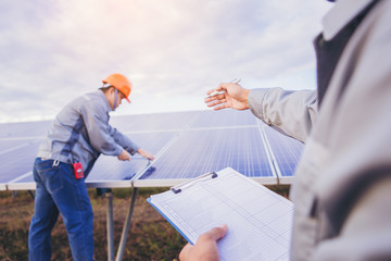 Boss hand and checklist order for worker use wrench to maintenance electric system at solar panel...