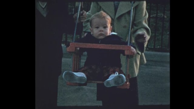 1953 50's family pushes baby in antique wooden swing