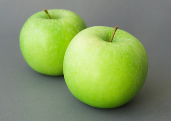 Green fresh apples fruit on grey background , healthy diet food concept