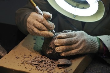 研究室で岩石を掘削する人