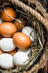 Fresh chicken eggs in an old wooden bucket.