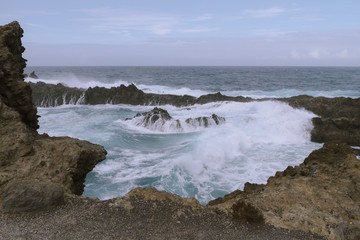 Obraz premium Breaking waves on coastline in dark cloudy weather