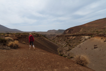 Girl walking in desert with mountains in background