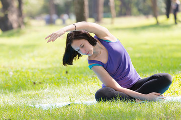 Holiday young woman doing yoga pose meditation in the public park Sport Healthy concept.