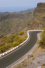 Road in rocky landscape with steep cliffs