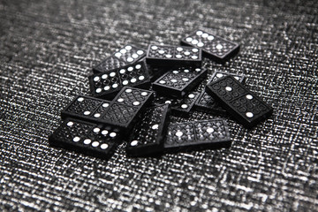pile of black dominoes ready for game on grey background