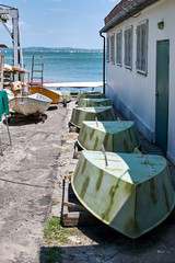 Fototapeta na wymiar Boats upside down on the pier near the house on a sunny day
