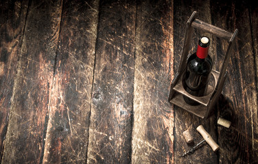Wine background. A bottle of red wine on a stand with a corkscrew.