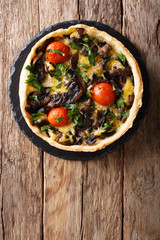 Freshly baked mushroom pie with cheese, parsley and tomatoes close-up. vertical top view