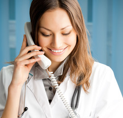 Young doctor on phone, at office