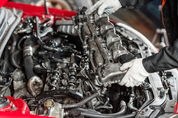 Fototapeta na wymiar Repairing of modern diesel engine, workers hands and tool. Car mechanic looking at engine for analysis symptoms of car at maintenance repair service station