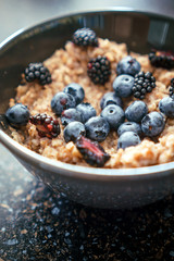 A plate of porridge of cereals with fresh berries blackberries and blueberries 2