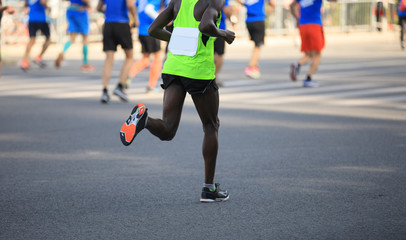 Fototapeta na wymiar marathon runner legs running on city road