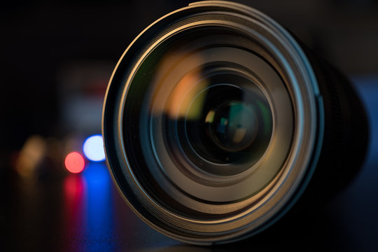 The photo or videocamera lens on dark background with lense reflections